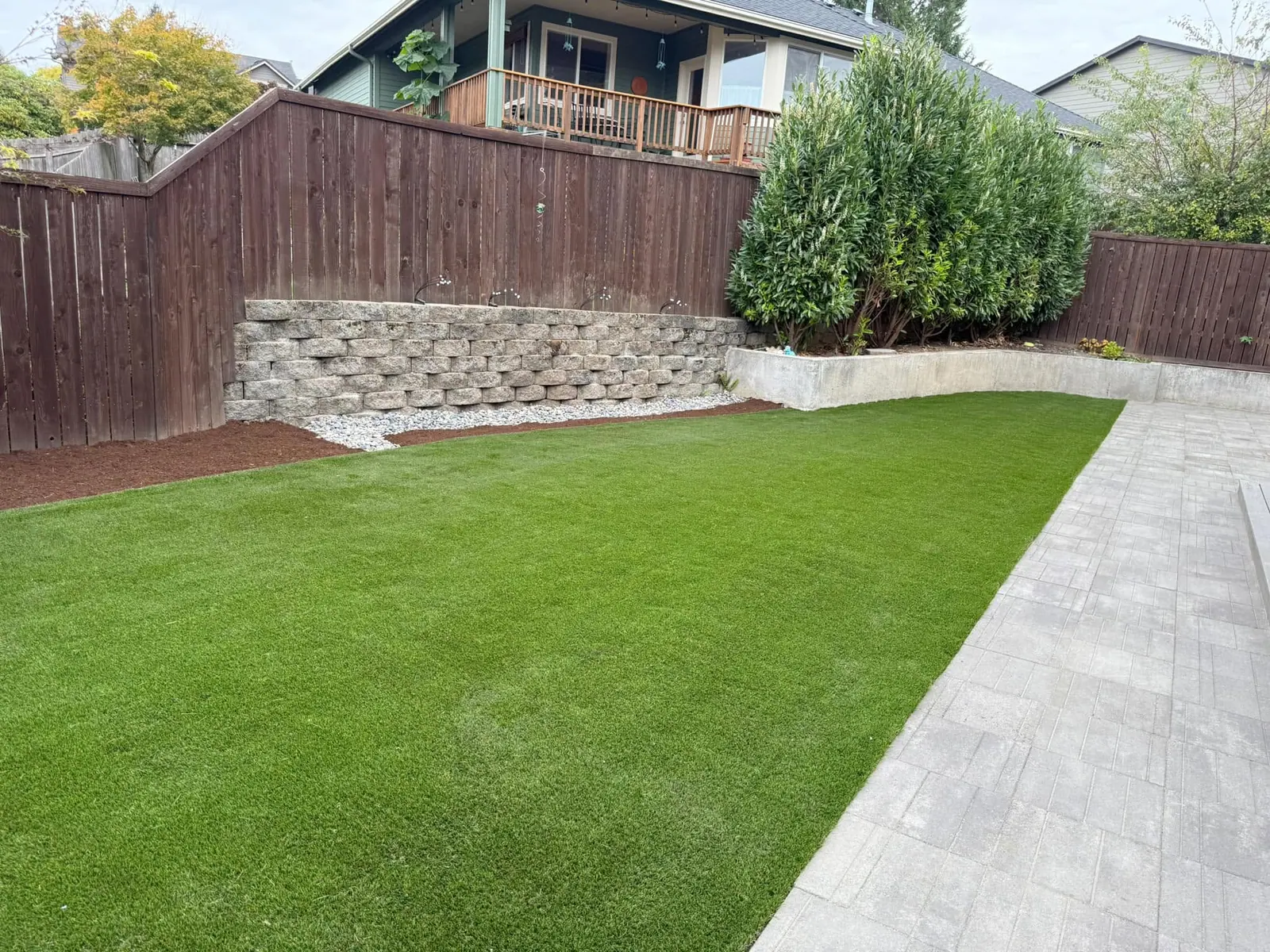 Artificial turf lawn built above a natural rock retaining wall
