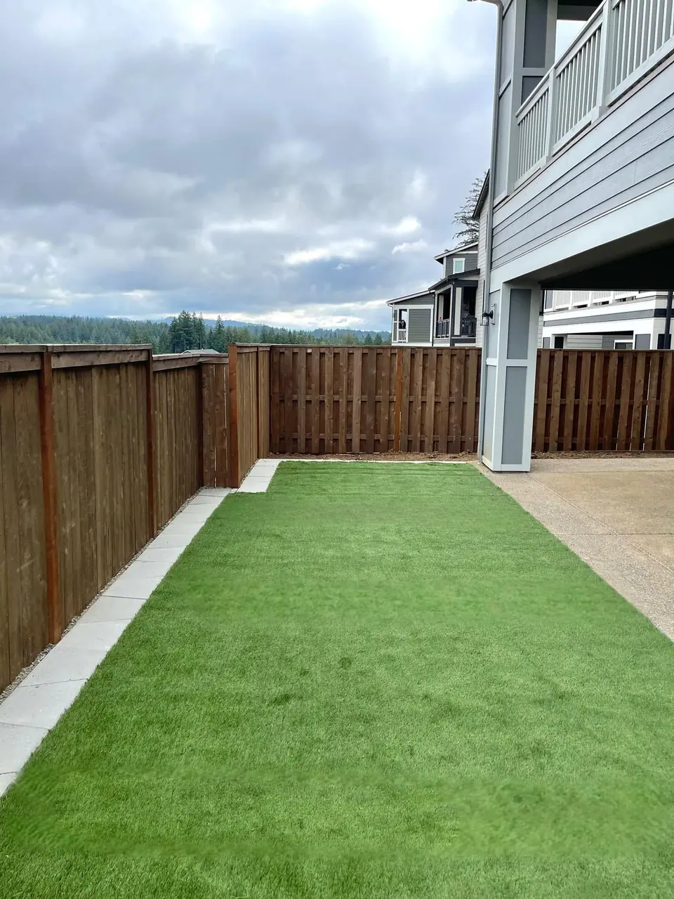 Artificial turf side yard finished between a fence and gate
