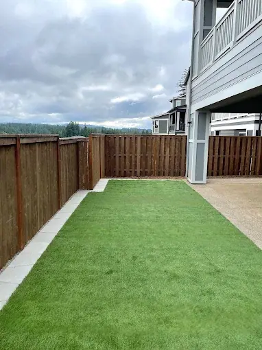 Artificial turf strip beside a carport and new cedar fence