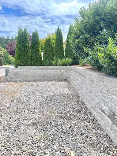 Block retaining wall wrapping a gravel yard ready for turf