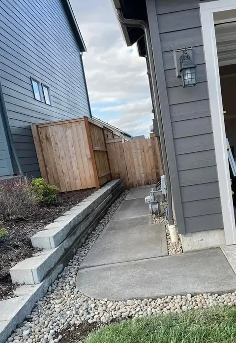Cedar gate framed into a fence line above a block retaining wall