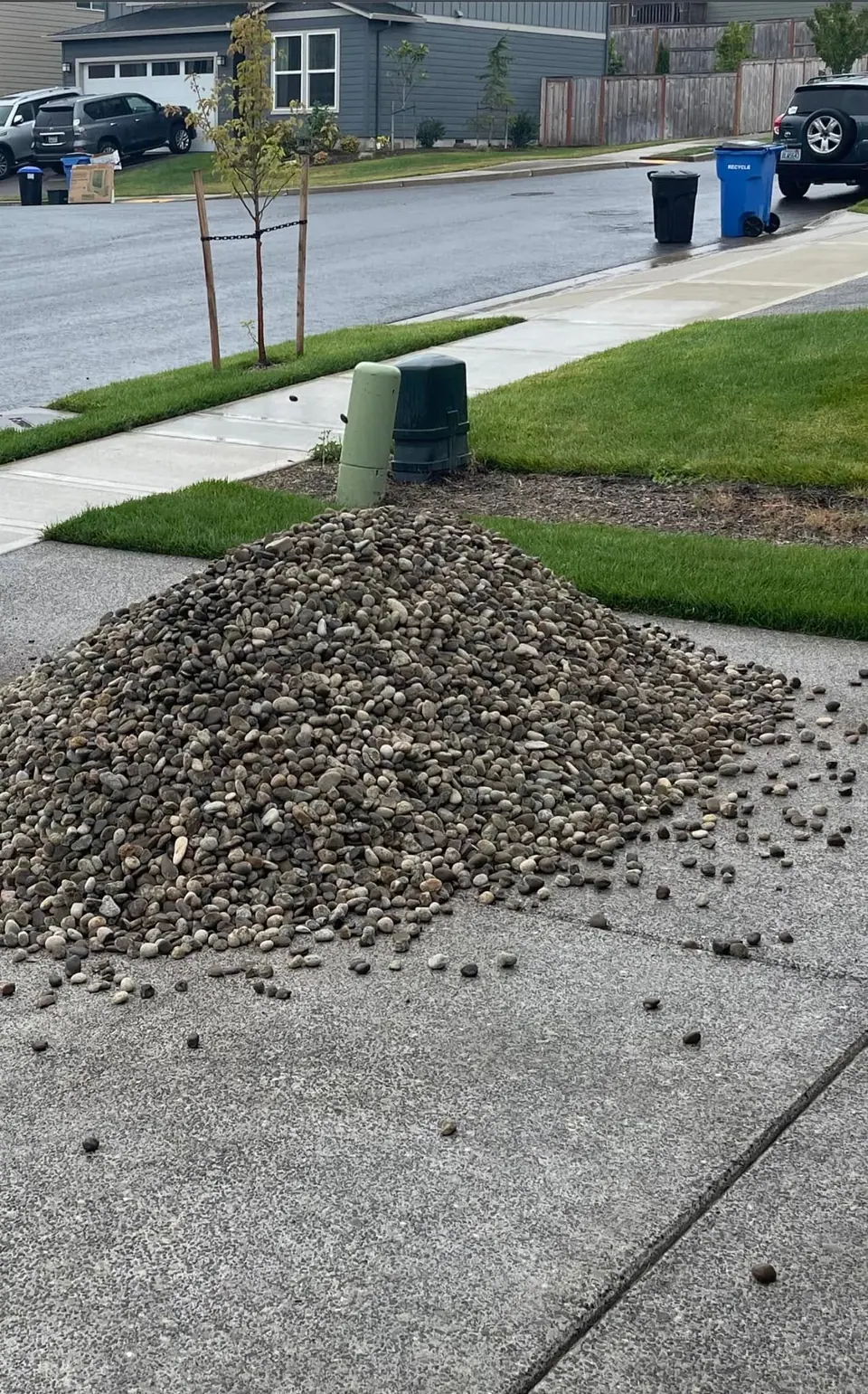 Crushed rock stockpiled on a driveway during a yard regrade