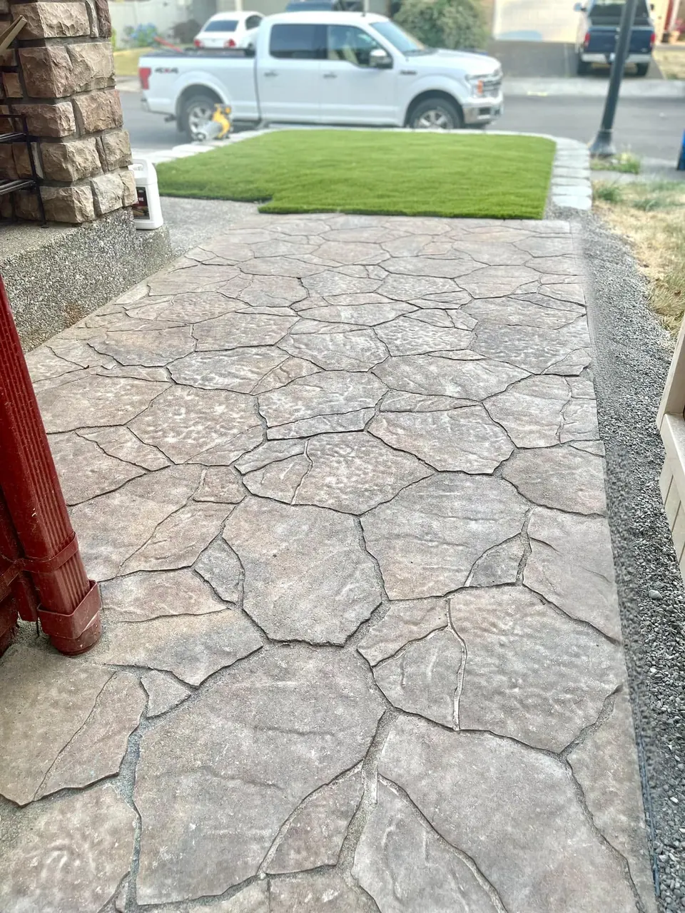 Decorative flagstone-pattern concrete patio with a fence surround