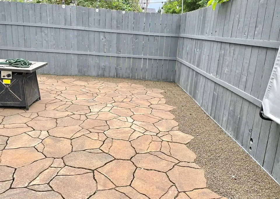 Flagstone patio laid in a fenced backyard with a seating area