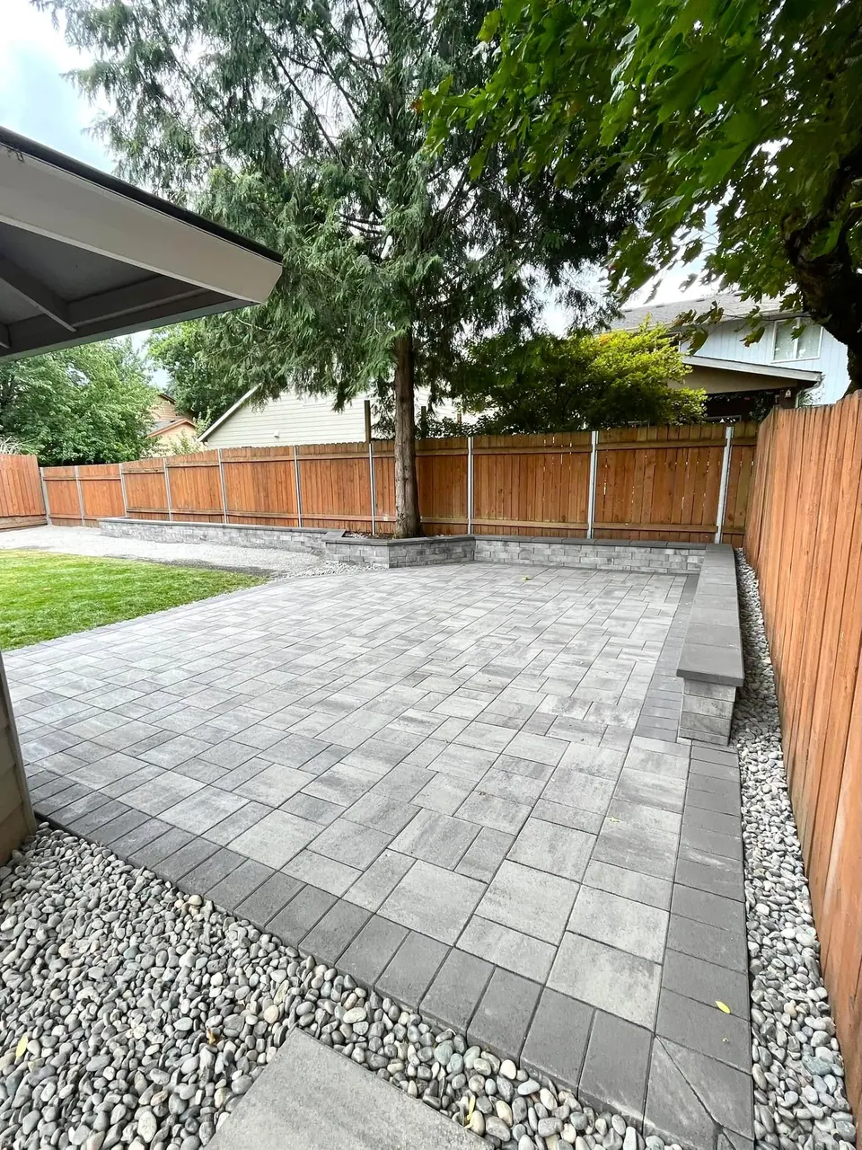 Large paver patio with an integrated seat wall and fence surround