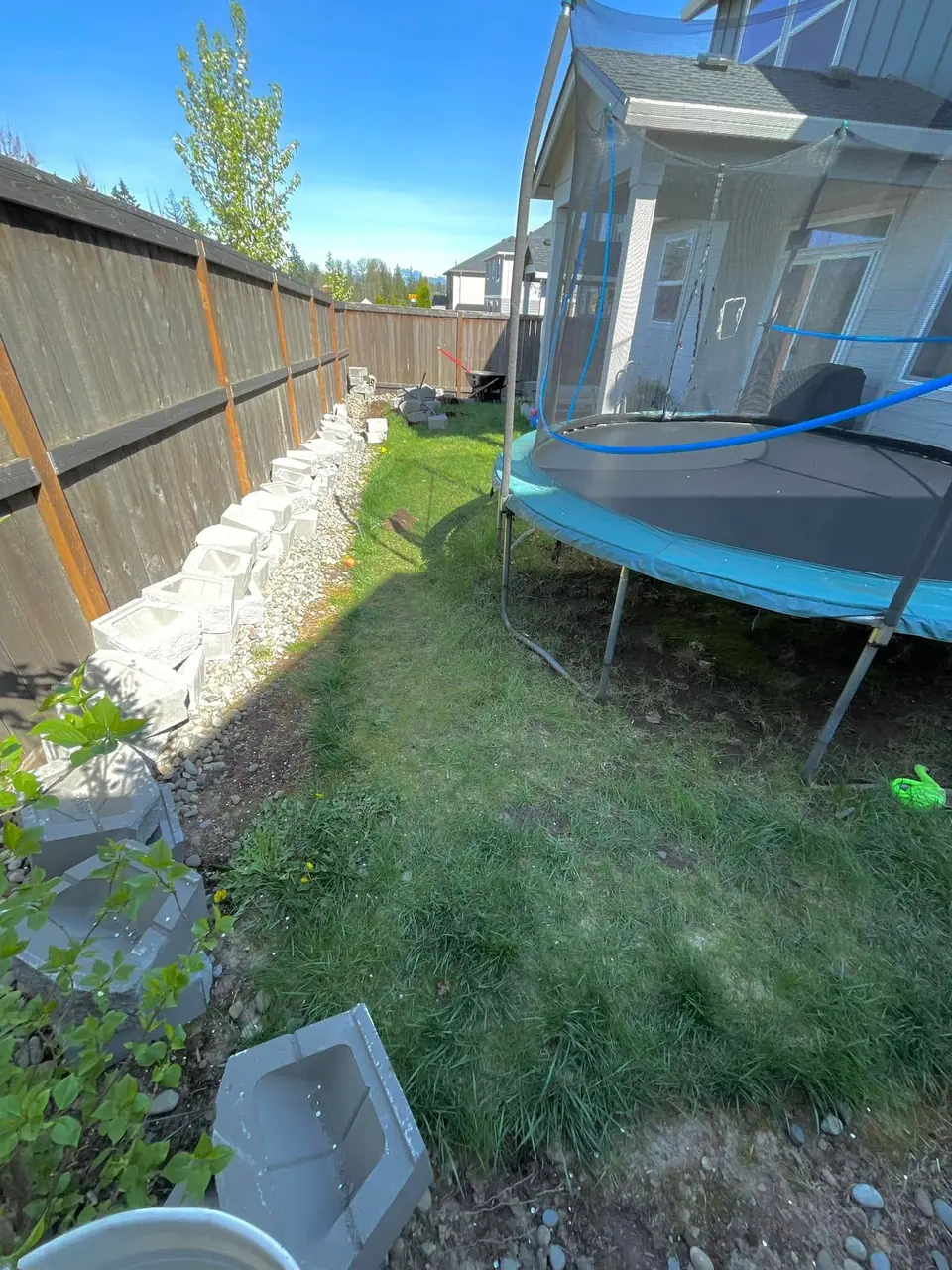 Natural rock retaining wall holding a grade beside a play area