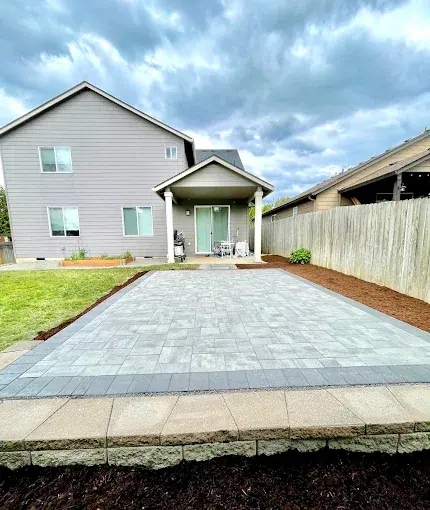 Paver patio installed the full width of a fenced backyard