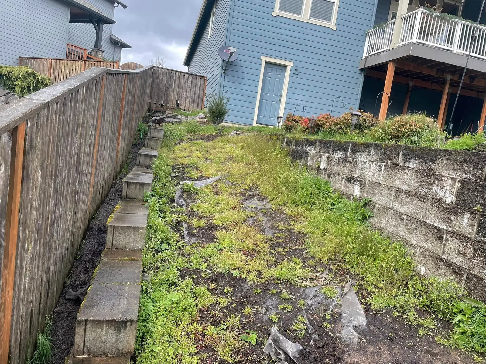 Stepped block retaining wall following a sloped fence line