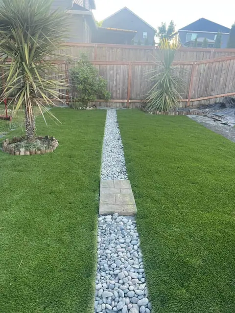 Stepping stone and gravel strip set into a lawn beside a planter
